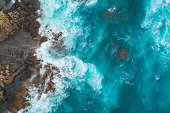 Aerial view of waves splashing on beach.