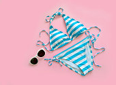 Sunglasses and blue and white swimsuits. Beach fashion in summer.
