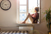 Young woman looking out of window