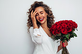 Beautiful emotional woman holding bouquet of flowers