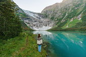 Woman standing on the background of Jostedalsbreen  glacier