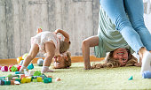 Mother and daughter standing upside down on the carpet at home