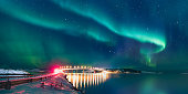 Sommaroy Bridge is a cantilever bridge connecting the islands of Kvaloya and Sommaroy with Aurora Borealis - Hillesoy Tromso Norway