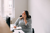 Happy Plus Size Female Office Manager Talking on the Phone