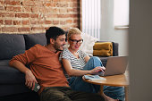 Loving Couple Relaxing in the Afternoon and Watching Something on the Laptop Computer