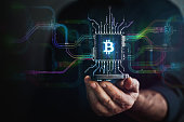 Crypto Currency in your hand. Male hand holding futuristic BTC chip in the center and circuit board with vibrant data transfers, representing evolving crypto payment technology of the future.