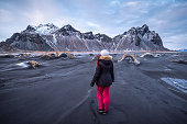 woman exploring Stokksnes with Vestrahorn mountain in the background
