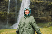Happy Woman Contemplating Dramatic Natural Landscapes With Waterfall View