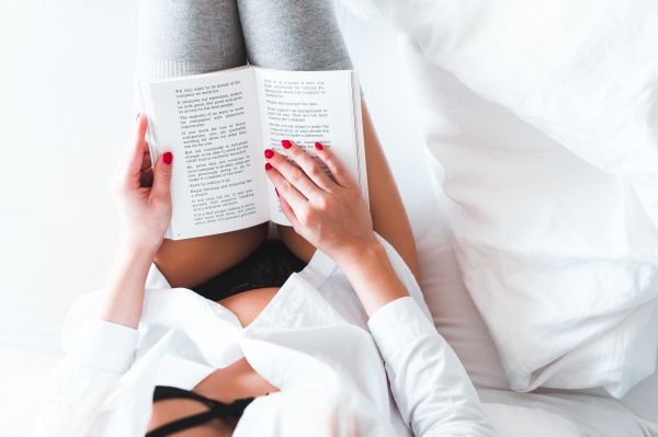 Woman Reading a Book in Bed Free Stock Photo